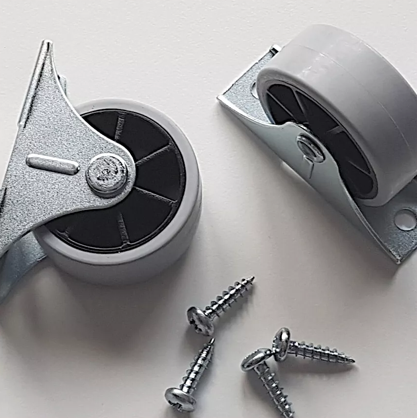 Photo de deux roues en plastique avec support metal pour remplacement sur meuble IKEA et quatre vis adaptées. La référence des roues est 111401 et celle des vis est 109049.